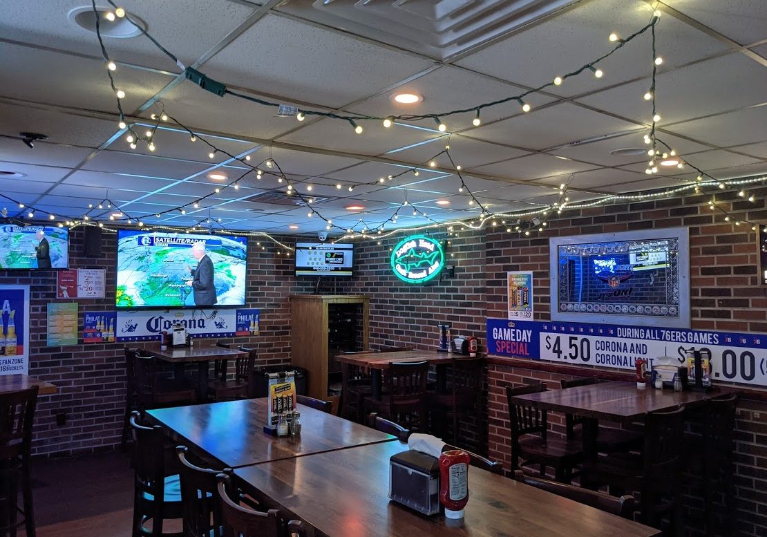 A bar with blue lights hanging from the ceiling.